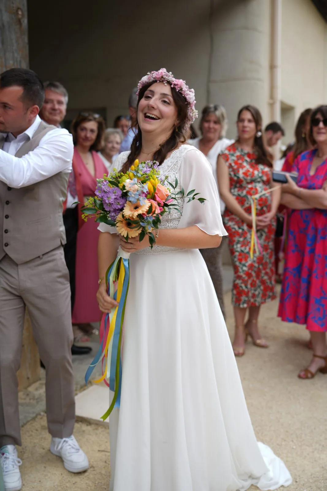 La mariée éclate de rire, entourée de ses invités