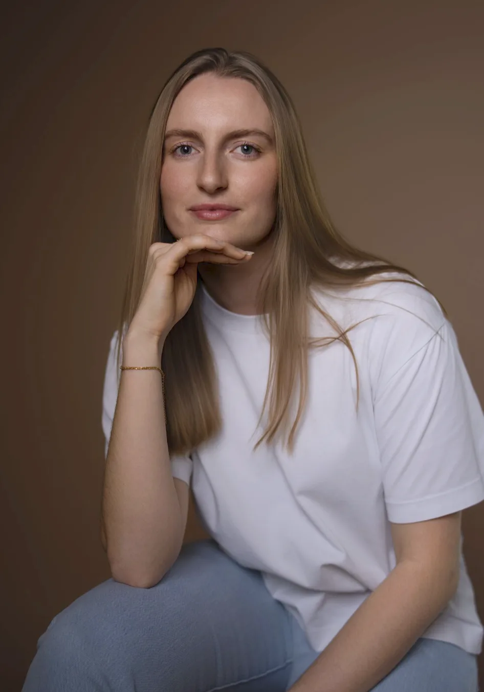 Portrait serré, main sous le menton, longs cheveux blonds