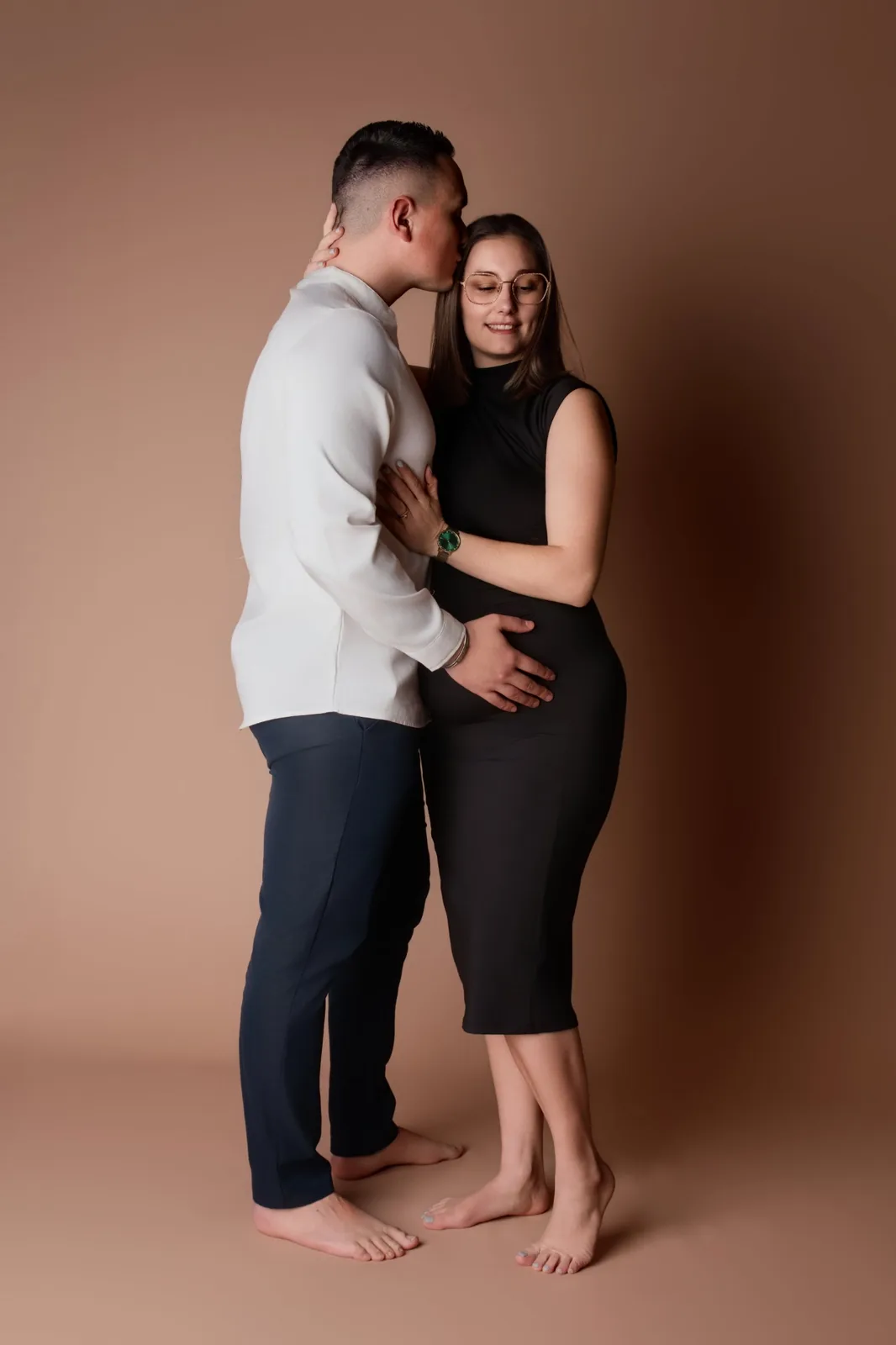 Futurs parents enlacés, baiser sur le front