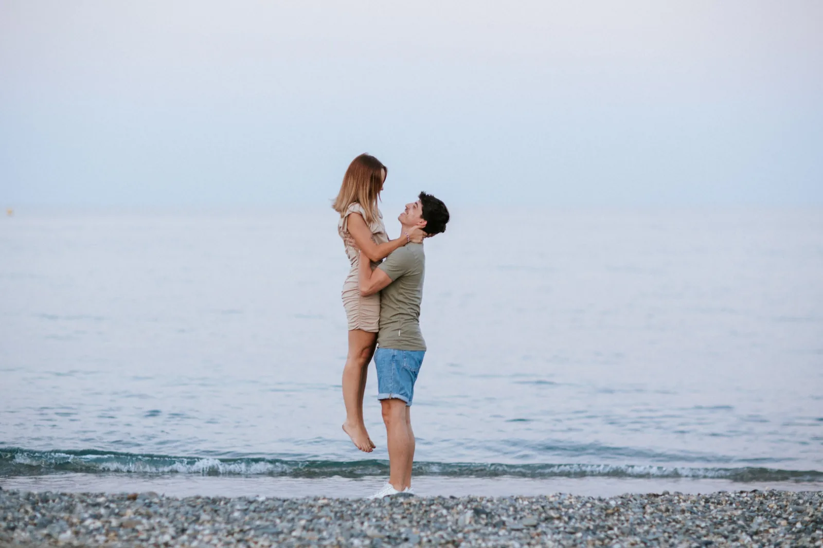 Il la soulève dans ses bras au bord de l’eau