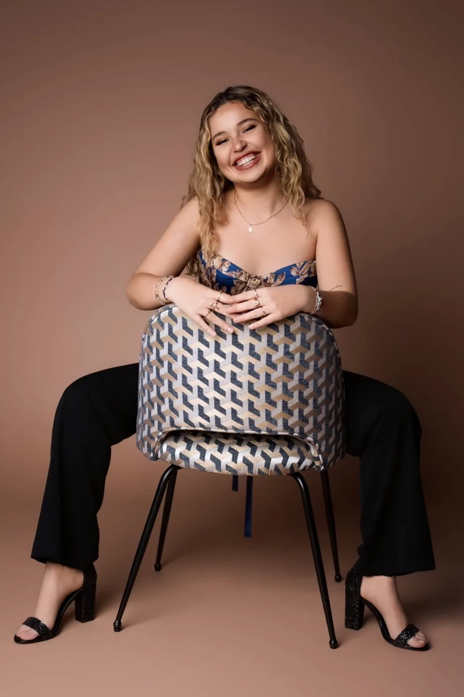 Kelya riant, assise à l’envers sur une chaise